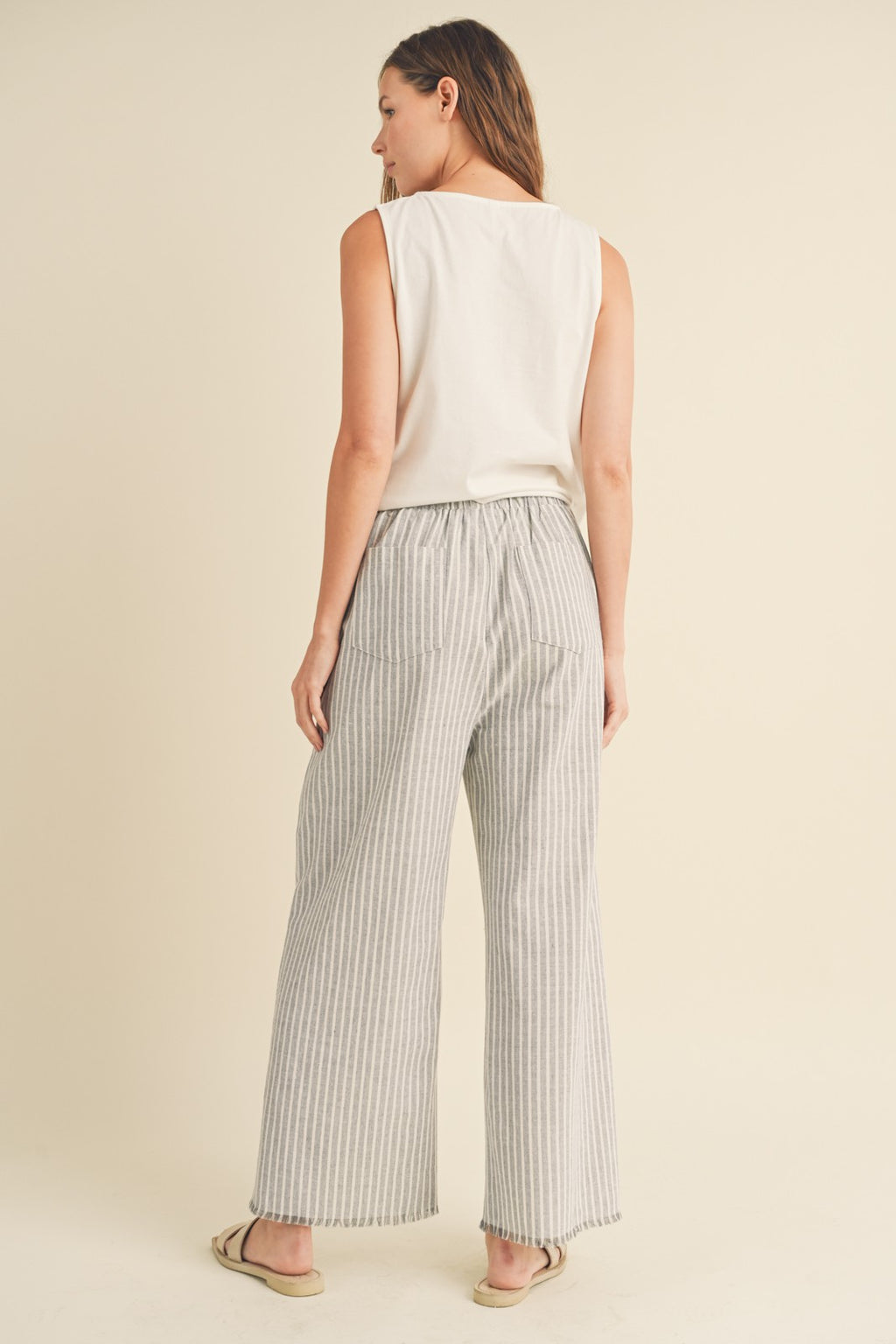 pinstripe linen pants with a high rise elastic waist, raw hemline and dual front pockets