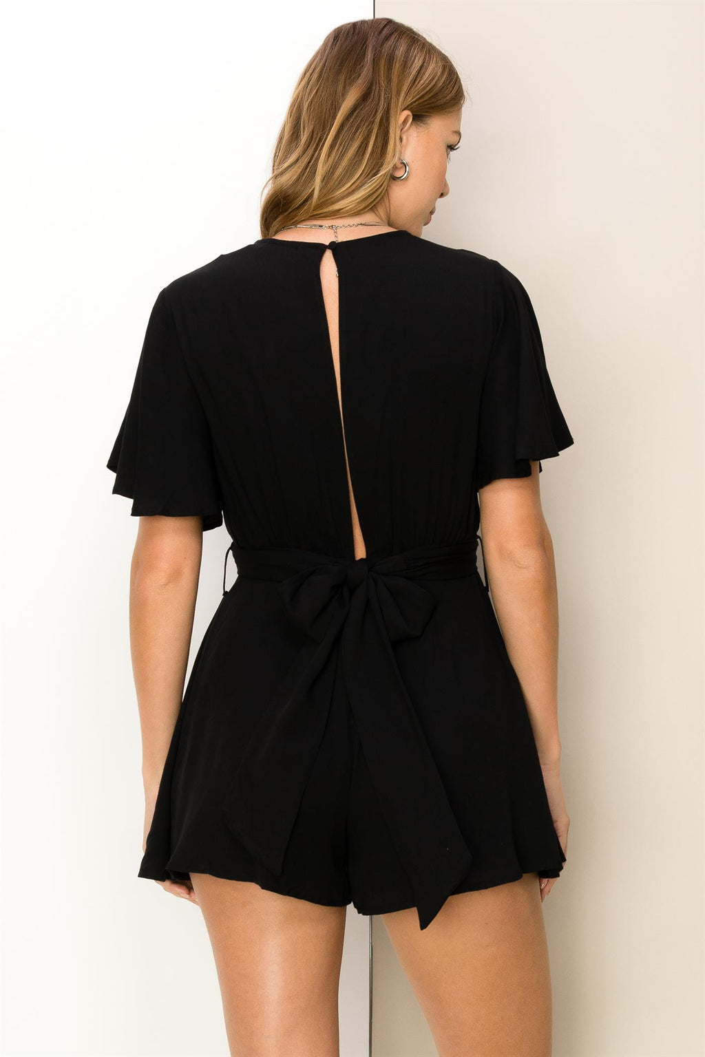 flutter sleeve tie back black romper with a v neck line and criss cross front detail